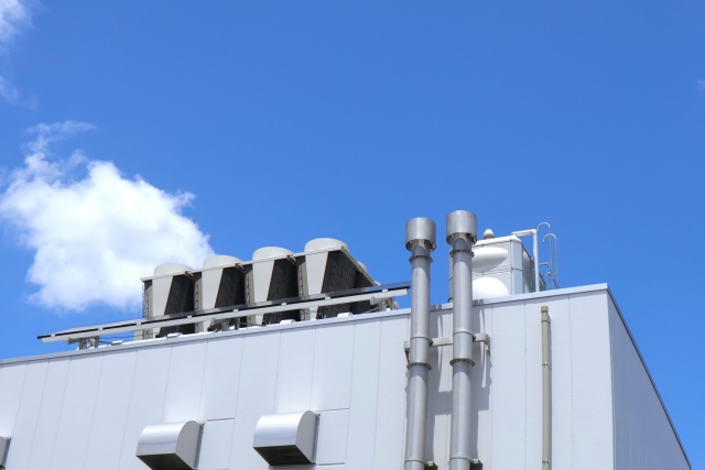工場建物の屋上に設置された大型の排気ダクトと機械設備