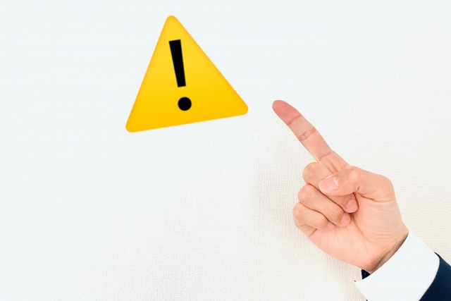 注意マークを指差している手元のイメージ