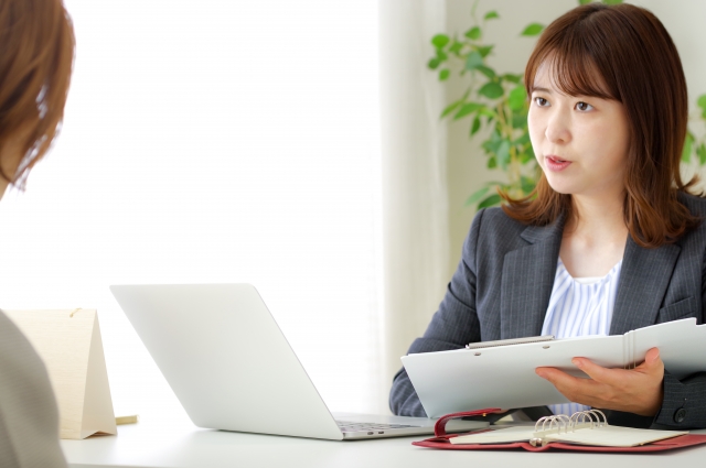 資料を使って提案をする女性スタッフ